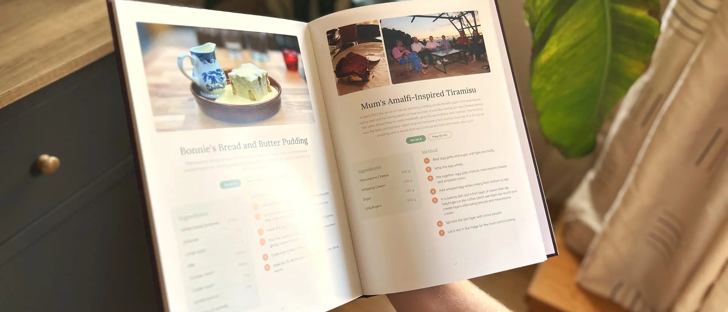 An open personalised cookbook showing a bread and butter pudding recipe beside a family's tiramisu page